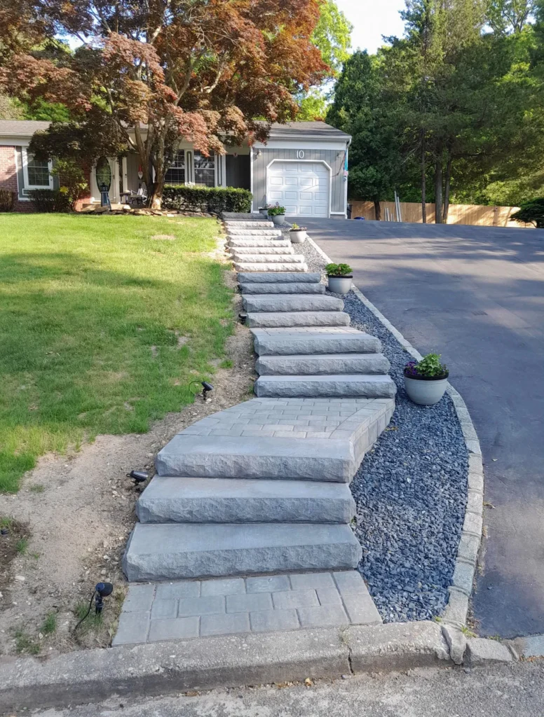 Natural stone and granite hillside outdoor steps with crushed stone gravel borders and planter pots in Stamford CT
