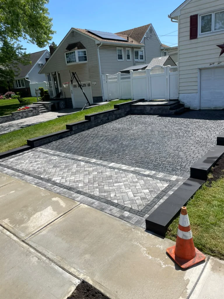 Interlocking paver driveway with custom herringbone paver apron and dark retaining curbing in Stamford CT